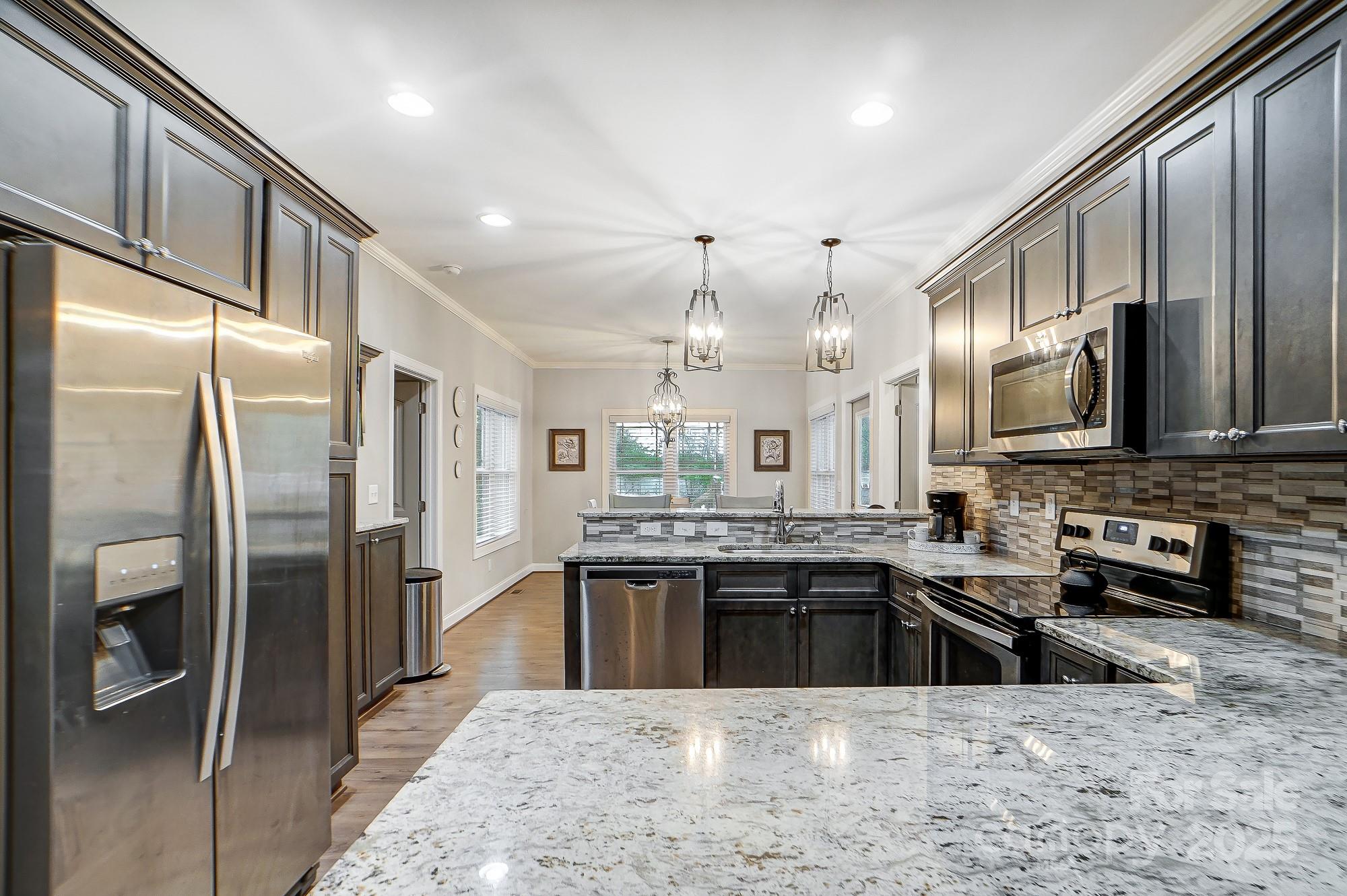 125 Jefferson Drive Locust, NC 28097 - Photo 12 of 27 a kitchen with stainless steel appliances granite countertop a sink stove and refrigerator