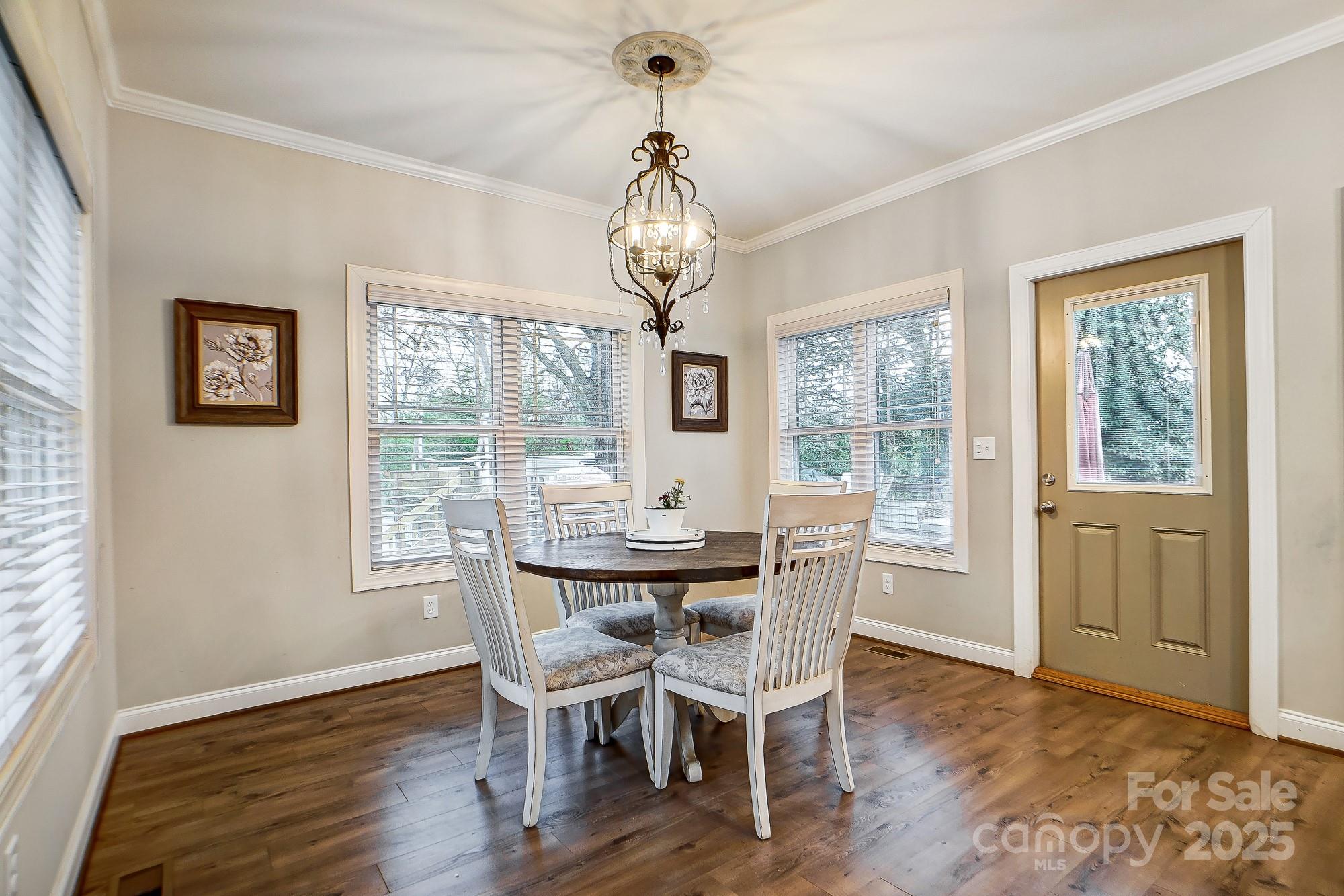 125 Jefferson Drive Locust, NC 28097 - Photo 13 of 27 a dining room with wooden floor a chandelier a wooden table and chairs