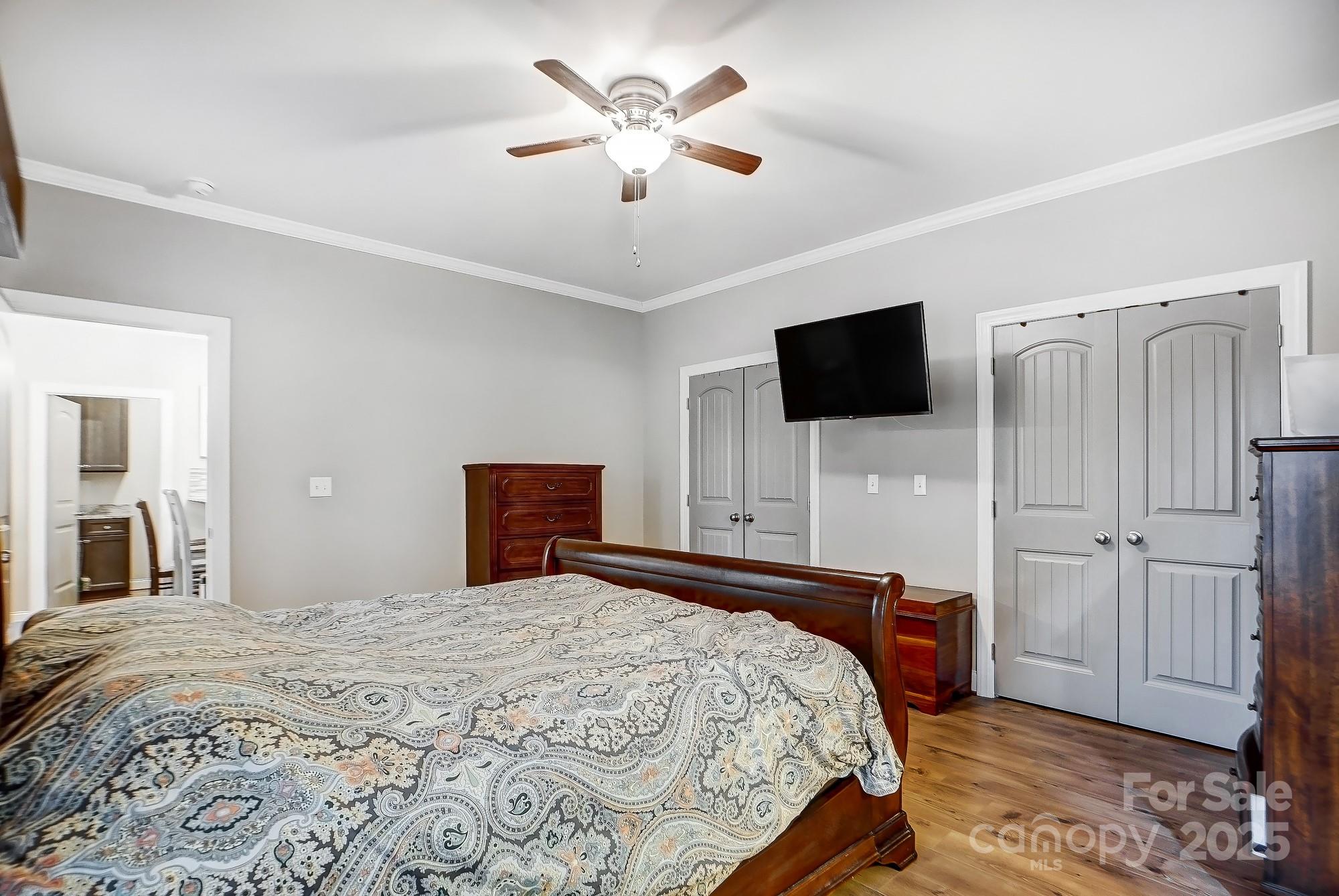 125 Jefferson Drive Locust, NC 28097 - Photo 18 of 27 a bedroom with a bed and a flat tv screen on wall
