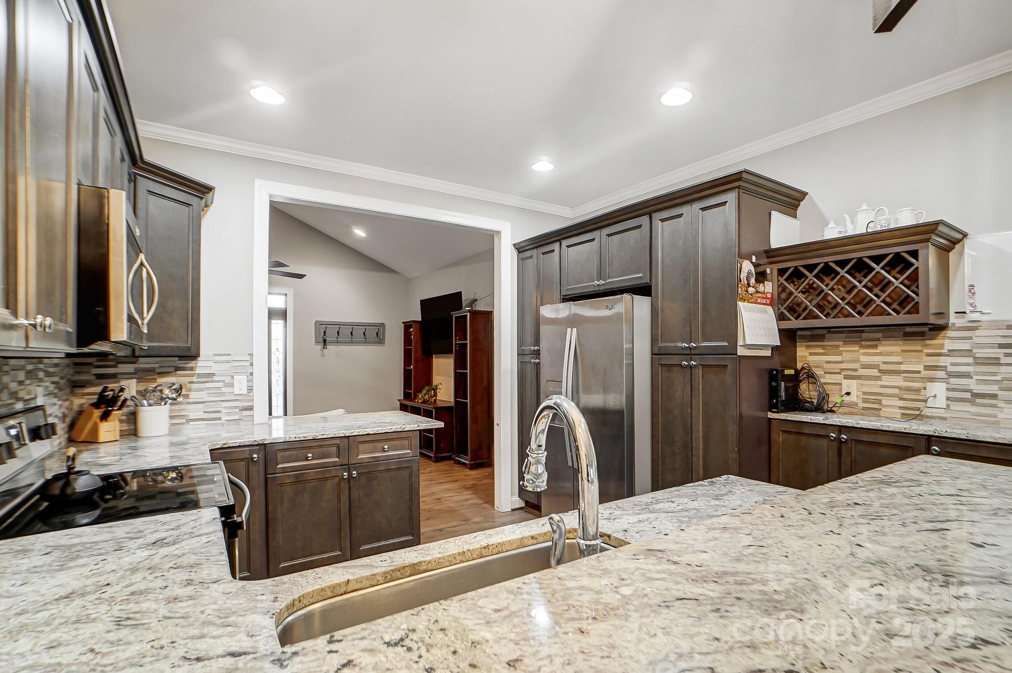 125 Jefferson Drive Locust, NC 28097 - Photo 9 of 27 a kitchen with stainless steel appliances kitchen island granite countertop a refrigerator and a sink