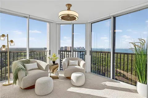 a living room with furniture and a floor to ceiling window