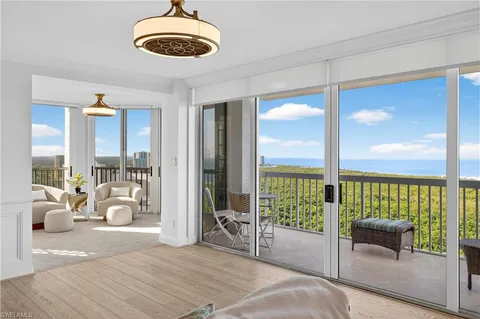 a bedroom with furniture and large windows