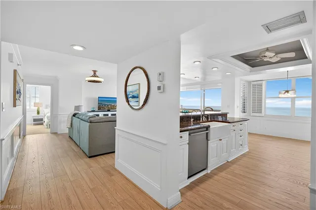 a kitchen with stainless steel appliances granite countertop a stove top oven and a sink with wooden floor