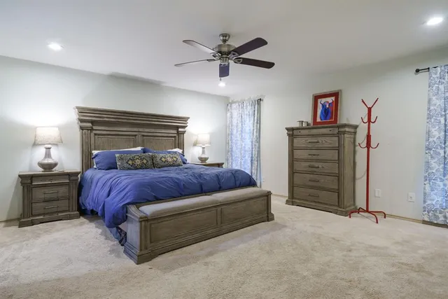 a bedroom with a bed and a ceiling fan