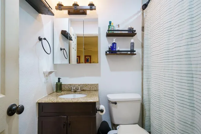 a bathroom with a sink a toilet and a mirror