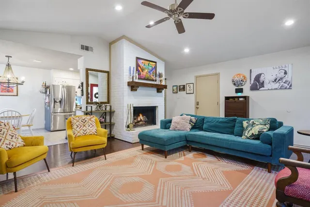 a living room with furniture a flat screen tv and a fireplace