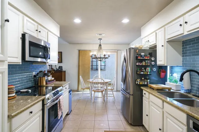 a kitchen with stainless steel appliances a stove sink and cabinets
