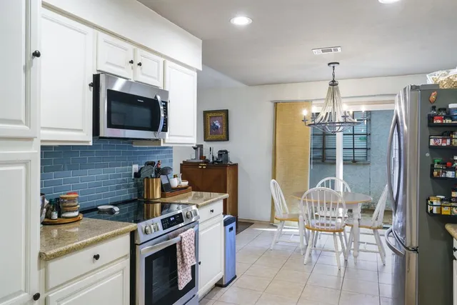 a kitchen with stainless steel appliances granite countertop a stove top oven a sink dishwasher and a microwave oven on the blue kitchen countertops