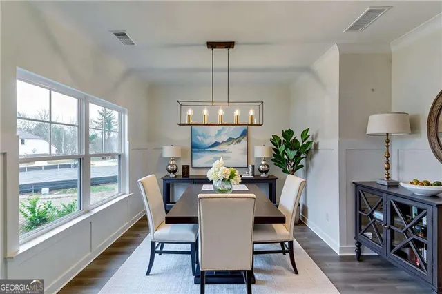 a dining room with furniture a potted plant and a chandelier