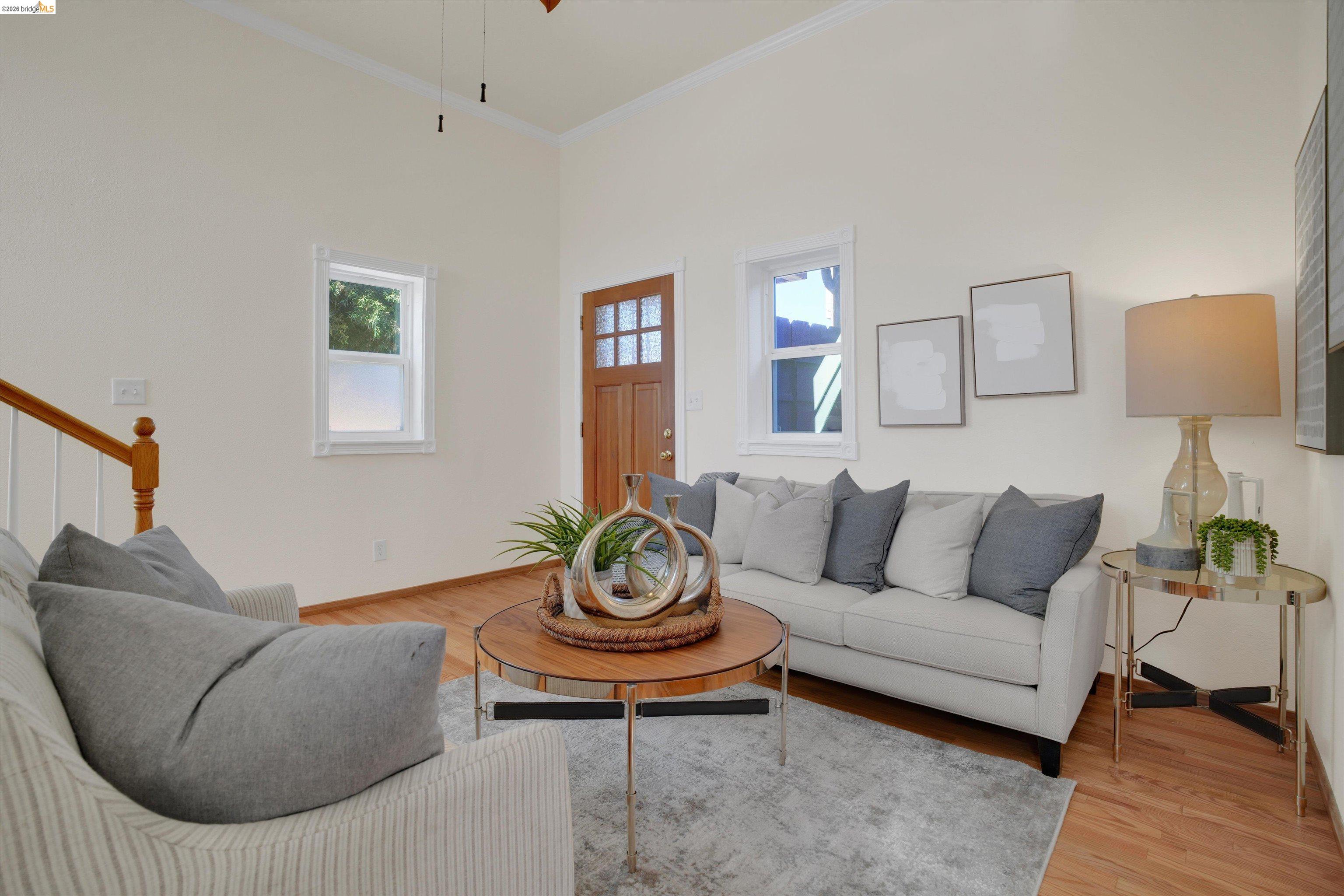 1821 Grand Street Alameda, CA 94501 - Photo 4 of 32 Living area featuring light wood-style floors, plenty of natural light, crown molding, a ceiling fan, and stairway