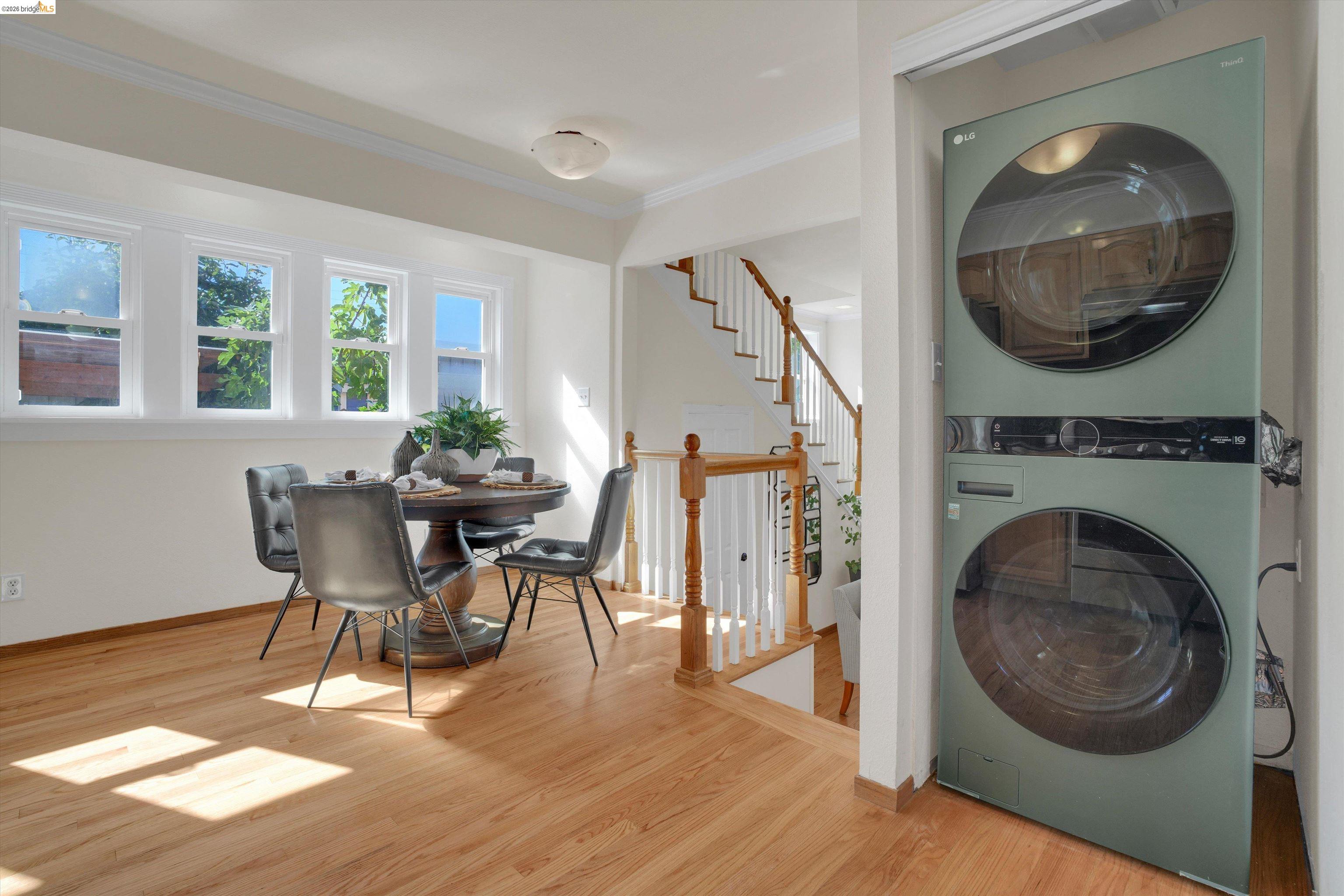 1821 Grand Street Alameda, CA 94501 - Photo 9 of 32 Laundry room featuring wood finished floors, stacked washer and clothes dryer, and ornamental molding