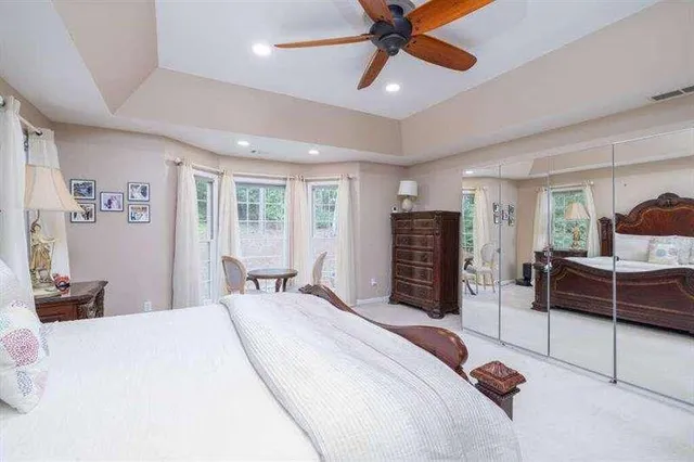 a bedroom with a bed and large windows