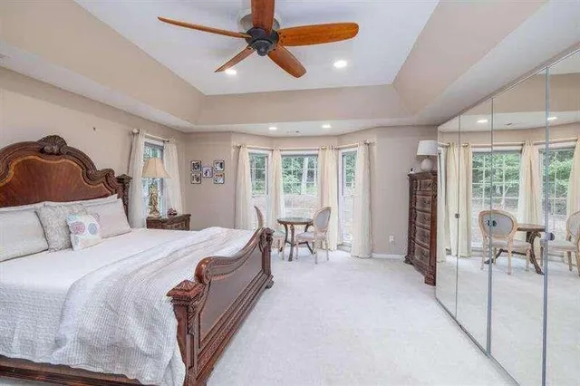 a bedroom with a bed a chandelier and dresser
