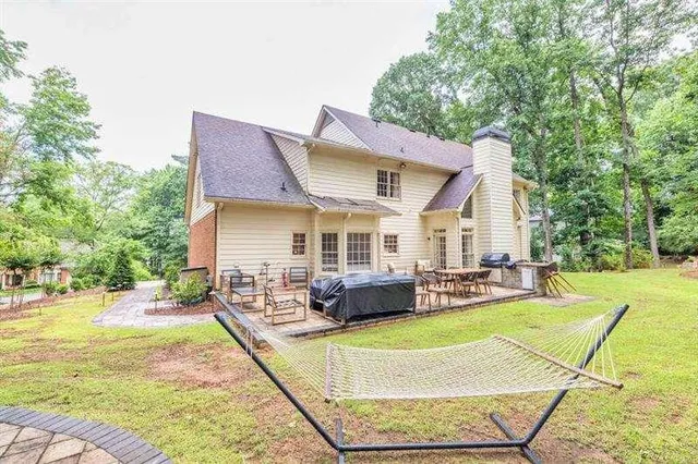 a view of a house with a patio and a yard