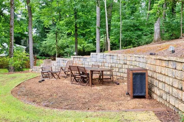 a view of swimming pool with lawn chairs and plants