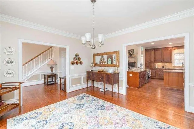 a large kitchen with kitchen island a large counter top stainless steel appliances a sink and living room view