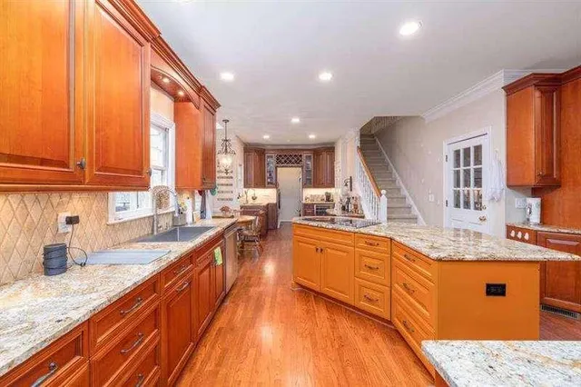 a large kitchen with stainless steel appliances kitchen island granite countertop a sink and cabinets