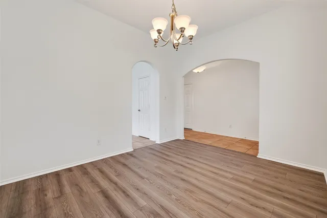 a view of a room with wooden floor and chandelier fan