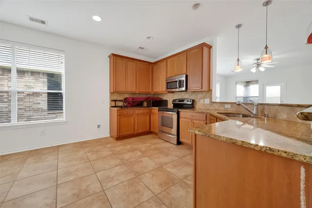 a kitchen with stainless steel appliances granite countertop a sink stove and cabinets