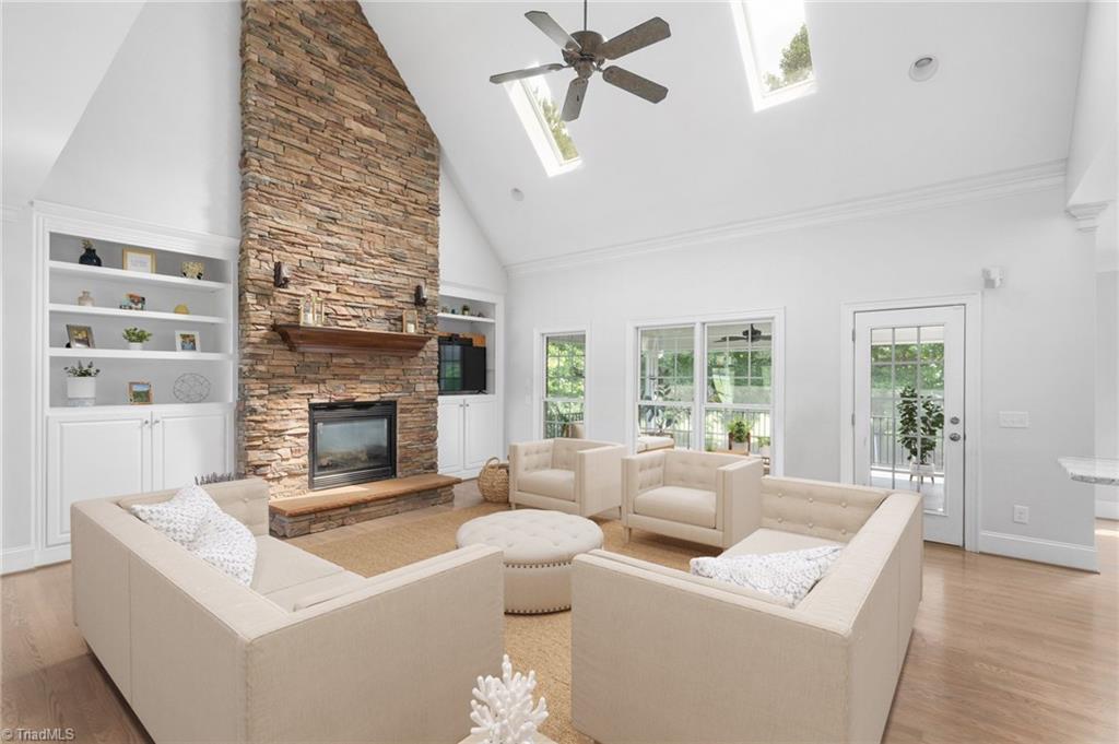 Bright Great Room with skylights, volume ceilings, floor-to-ceiling stone fireplace with raised hearth & built-in shelves and cabinetry. Virtually Staged