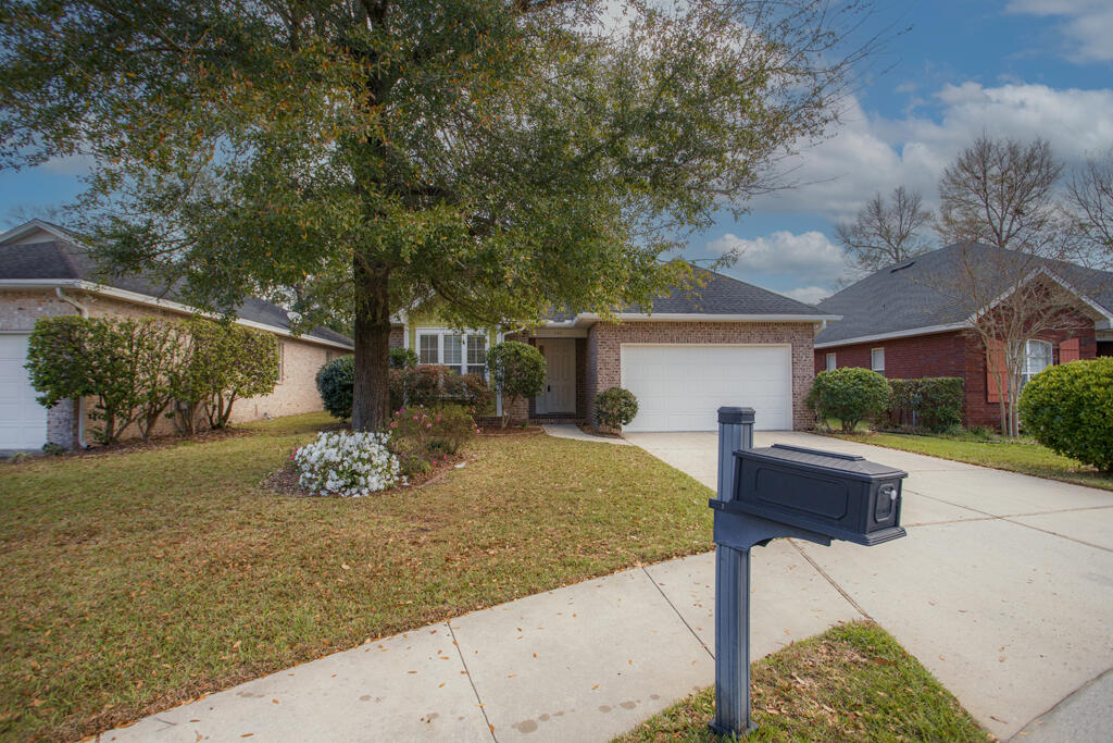 111 Arrowhead Way Niceville, FL 32578 - Photo 2 of 46 a front view of a house with a yard and a garage