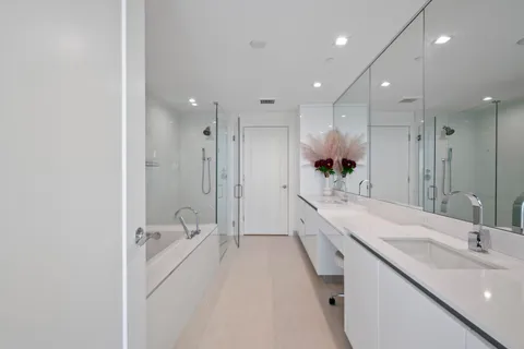 a large bathroom with a granite countertop sink a toilet a mirror and shower