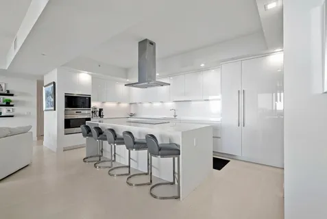 a kitchen with kitchen island white cabinets and stainless steel appliances