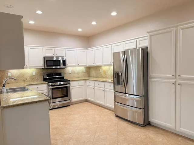 a kitchen with granite countertop a refrigerator and a sink
