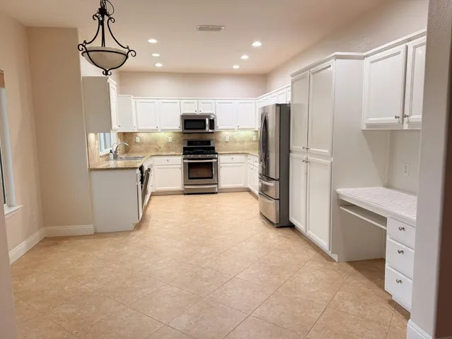 a kitchen with stainless steel appliances a refrigerator and a stove top oven