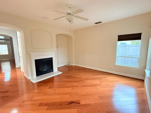 a view of empty room with wooden floor and fireplace
