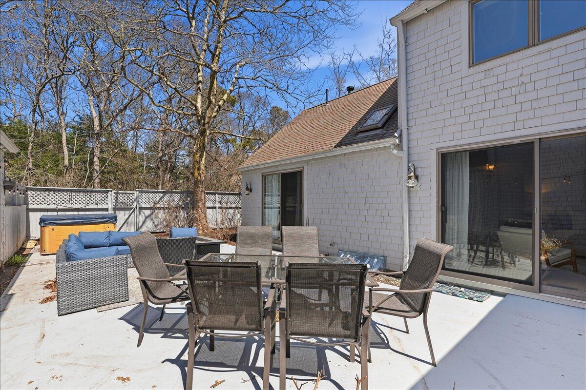 100 Mid-Iron Way, Unit 7027 Mashpee, MA 02649 - Photo 23 of 38 a view of a patio with table and chairs and floor to ceiling window