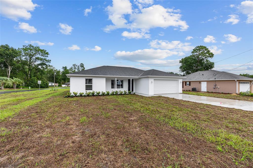13019 Northeast 7th Loop Silver Springs, FL 34488 - Photo 3 of 35 a front view of a house with a garden