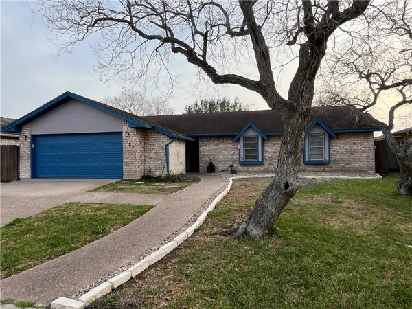 a front view of a house with a garden and yard
