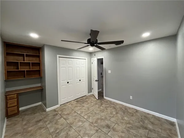an empty room with closet and windows