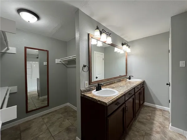 a bathroom with a double vanity sink and a mirror