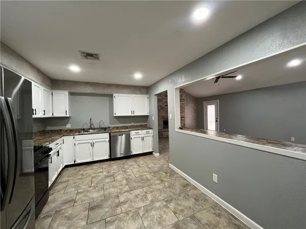 a large kitchen with stainless steel appliances lots of counter space and wooden floor