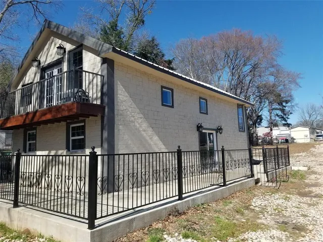 a view of a house with a small yard and wooden fence