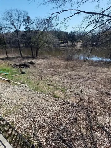 a view of a dry yard with wooden fence