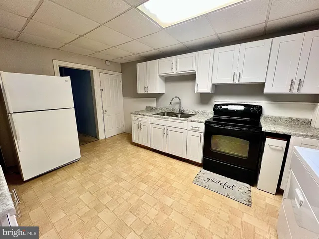 a kitchen with a stove sink and a refrigerator