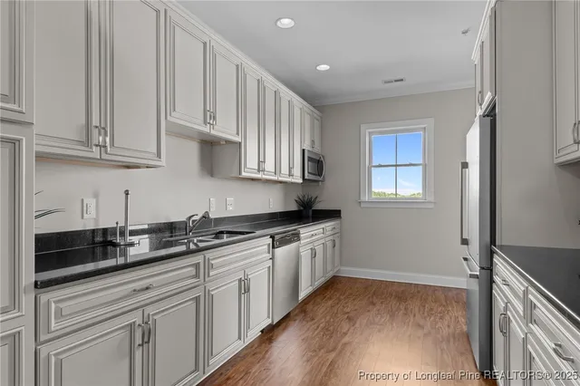 a kitchen with granite countertop white cabinets and sink