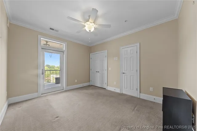a view of an empty room with chandelier fan