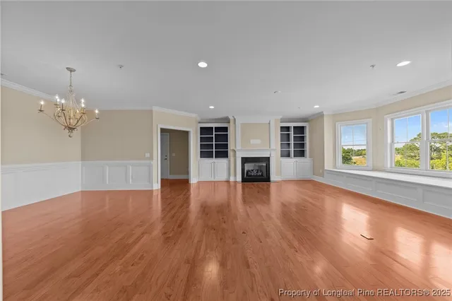 a view of empty room with wooden floor and fireplace