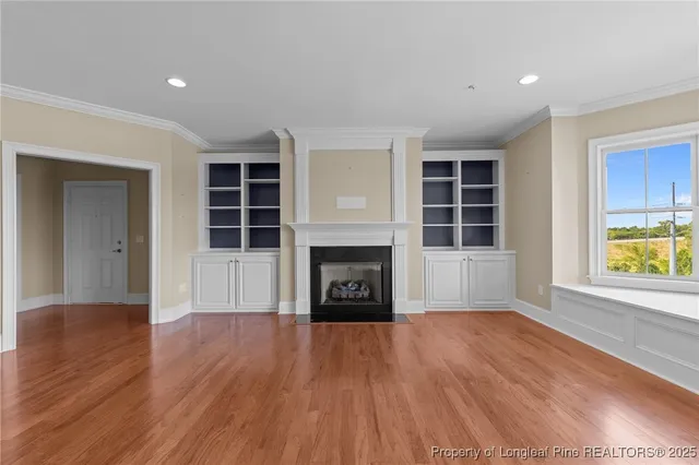 a view of an empty room with a window and fireplace