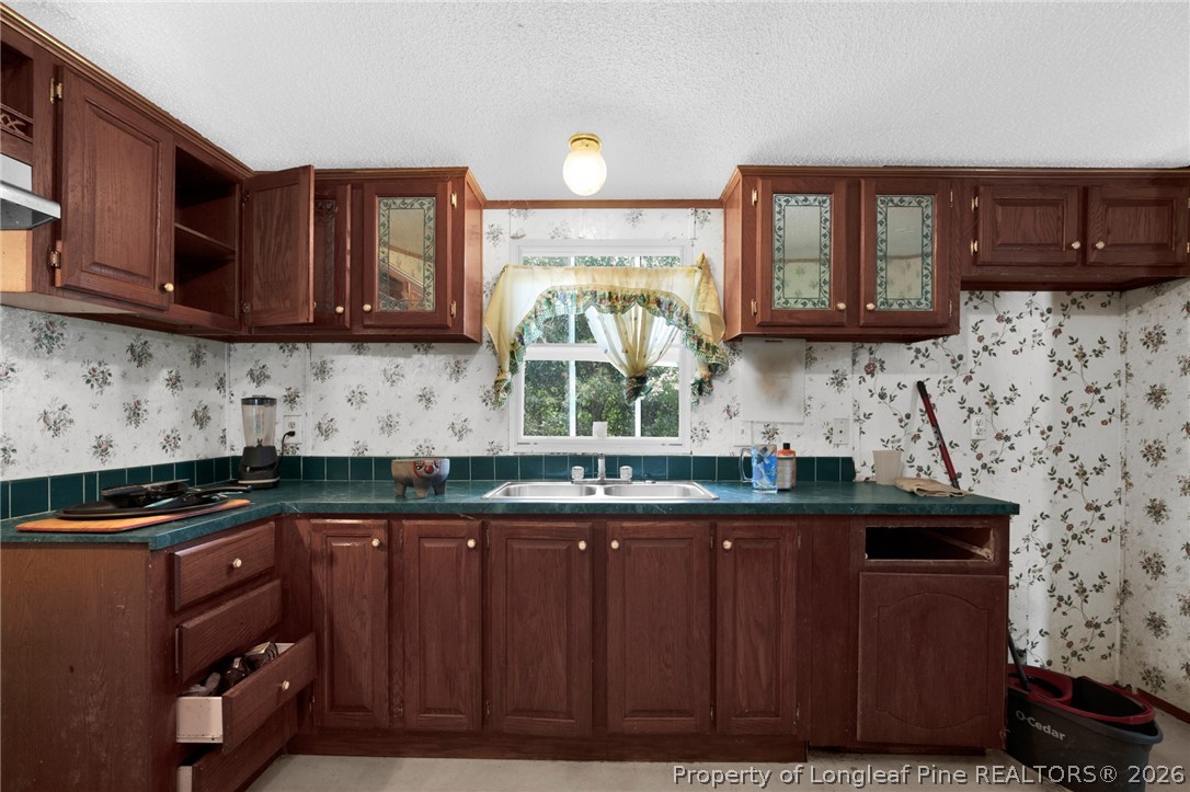 4705 Hickory Ridge Road Parkton, NC 28371 - Photo 16 of 37 a kitchen with granite countertop a stove a sink and a microwave