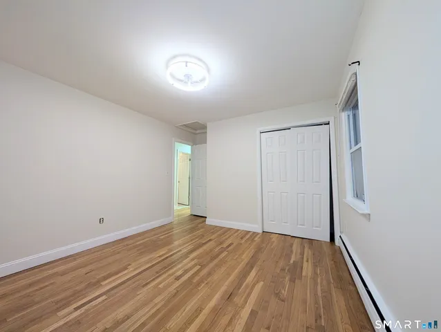 a view of empty room with wooden floor