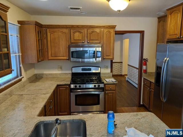 4 Lee Court Waldwick, NJ 07463 - Photo 13 of 15 a kitchen with a stove and a microwave