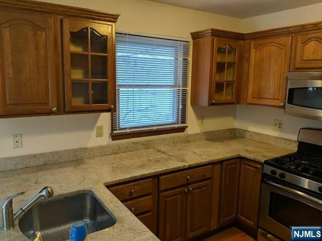 a kitchen with granite countertop a sink a stove and cabinets