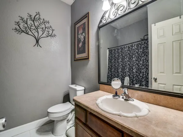 a bathroom with a sink a toilet and mirror