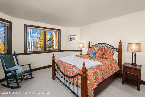 a bedroom with a bed a dresser and chair