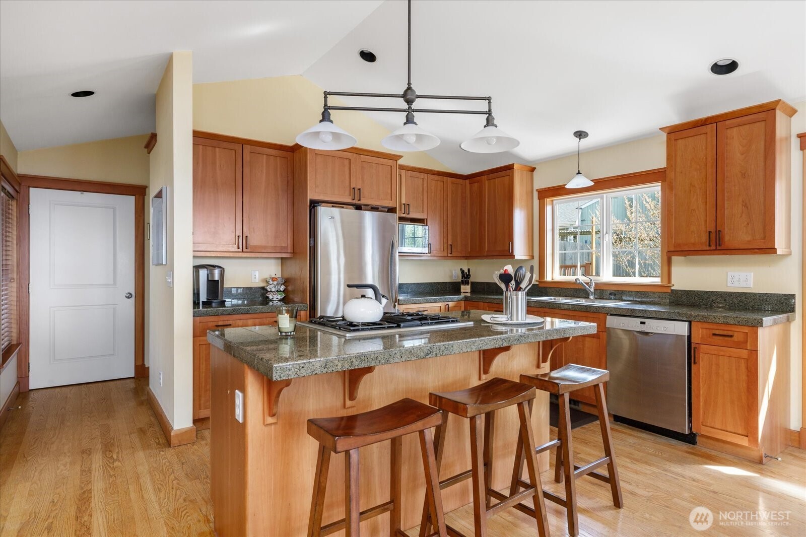 8210 Nob Road Clinton, WA 98236 - Photo 12 of 40 a kitchen with stainless steel appliances granite countertop a stove top oven a refrigerator a sink and dishwasher with wooden floor
